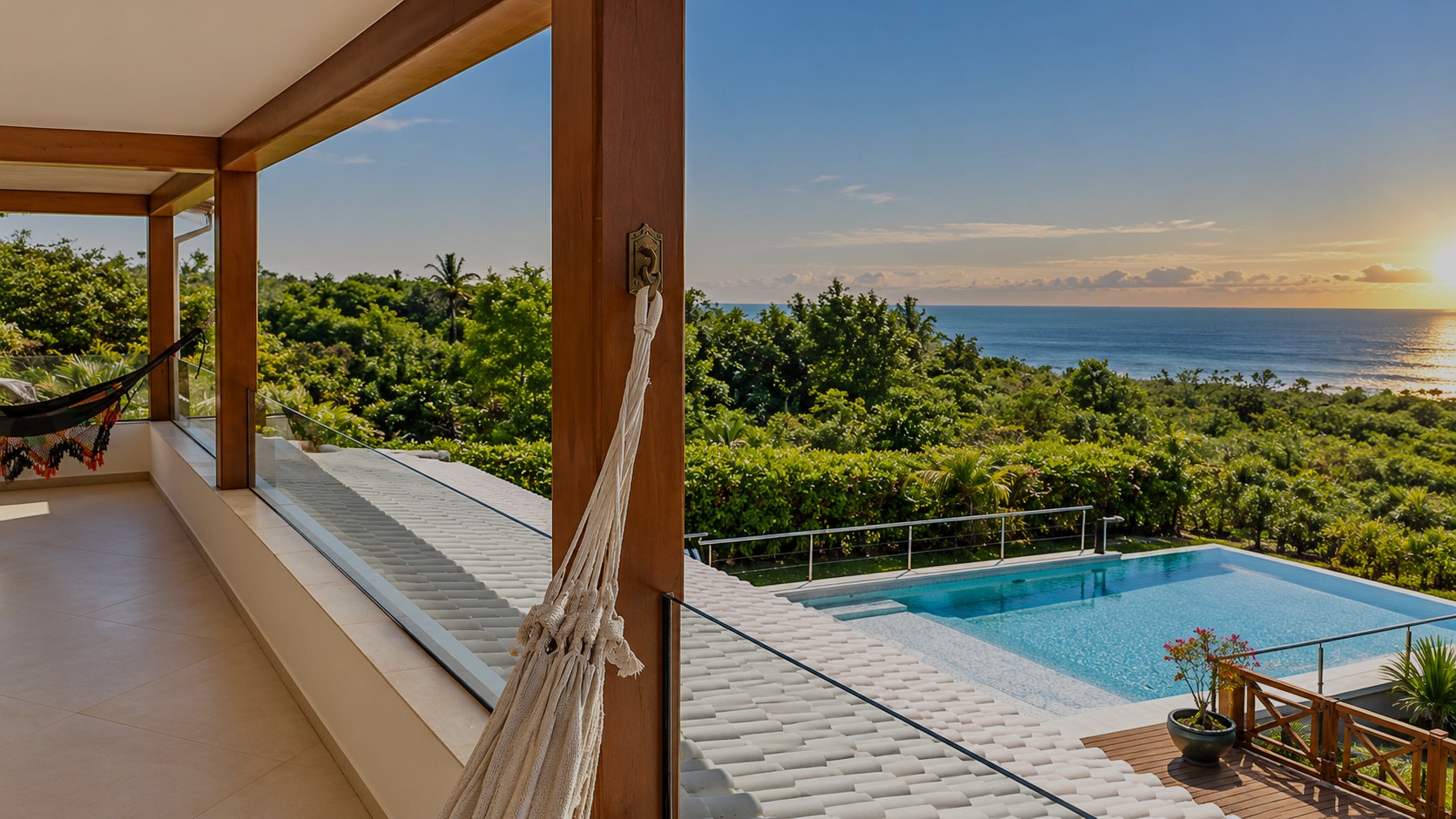 Überdachte Veranda im ersten Obergeschoss der exklusiven Küstenresidenz in Santa Cruz Cabrália mit Hängematten und Blick auf Pool und Atlantik.